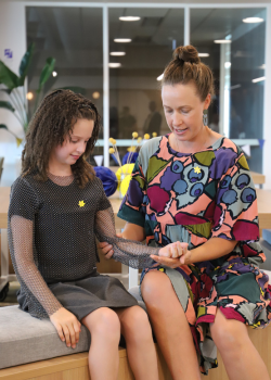 Sarah showing Imogen some simple physical therapy exercises